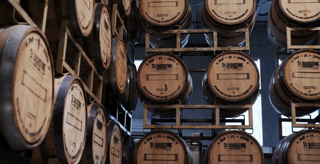 Wooden port barrels stacked in distillery warehouse aging premium whiskey spirits